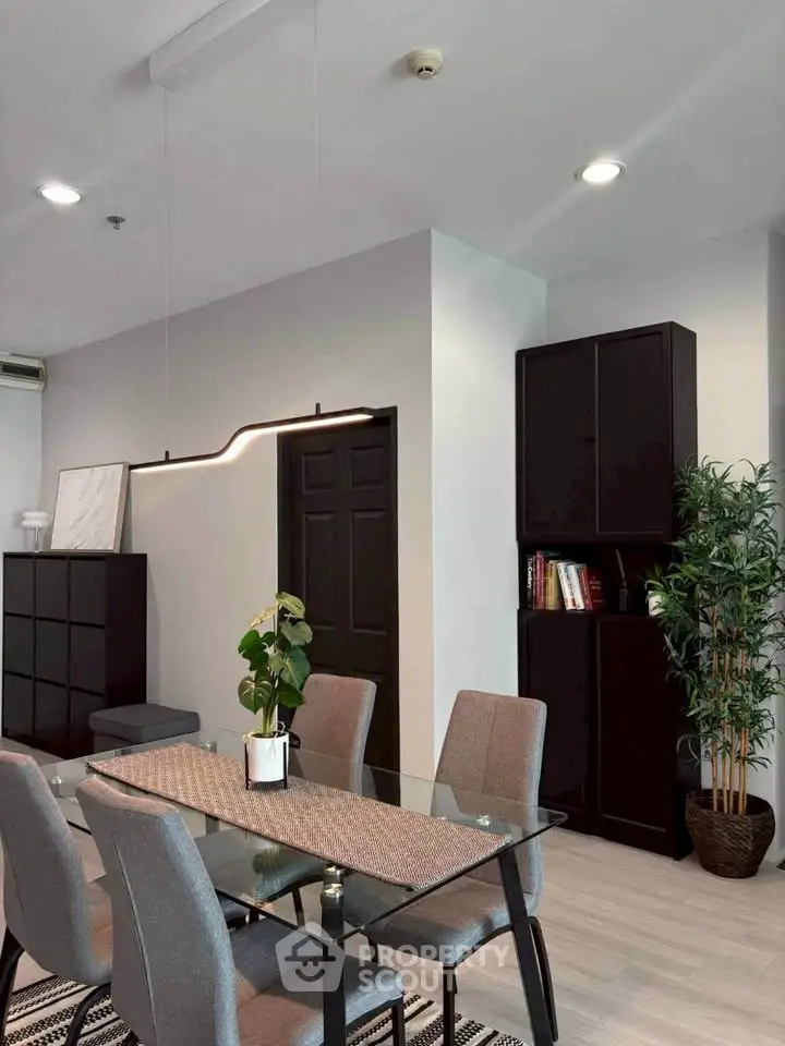 Modern dining area with glass table and stylish decor in a contemporary apartment.