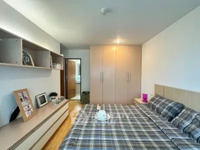 Cozy bedroom with plaid bedding and ample storage in modern apartment