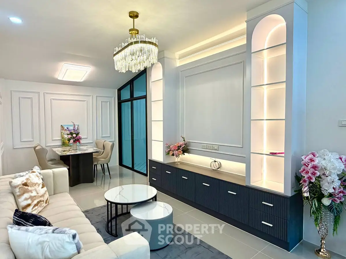 Elegant living room with modern decor, chandelier, and built-in shelving, perfect for stylish urban living.
