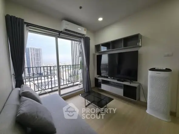Modern living room with balcony view and sleek furniture in high-rise apartment.