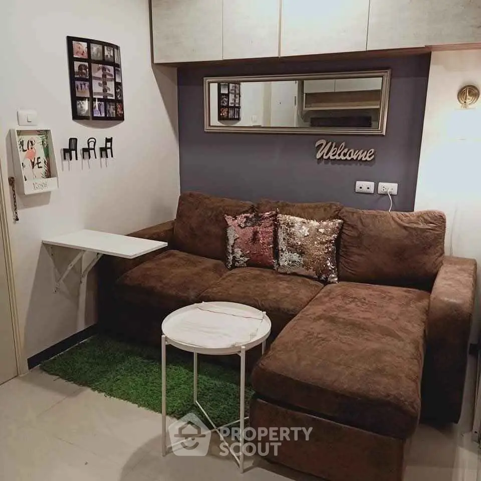Cozy living room with plush brown sofa, decorative pillows, and wall art for a welcoming ambiance.