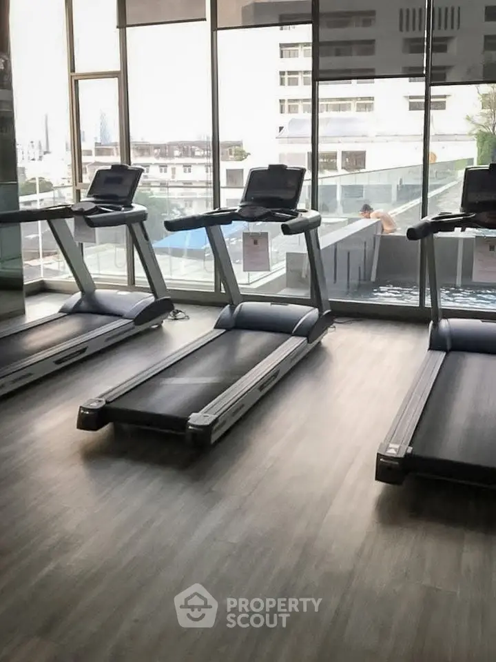 Modern gym with treadmills and large windows offering city views