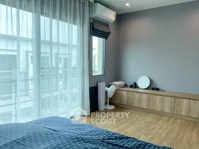 Spacious modern bedroom with large window and stylish decor
