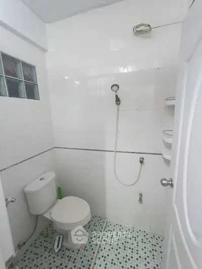 Compact bathroom with white tiles and shower, ideal for minimalist design enthusiasts.
