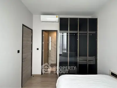 Modern bedroom with sleek wardrobe and ensuite bathroom