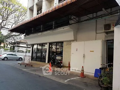 Commercial building exterior with parking area and street view.