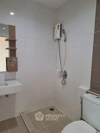 Modern bathroom with shower and toilet in a tiled setting