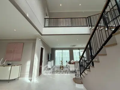 Spacious modern living room with high ceilings and elegant staircase