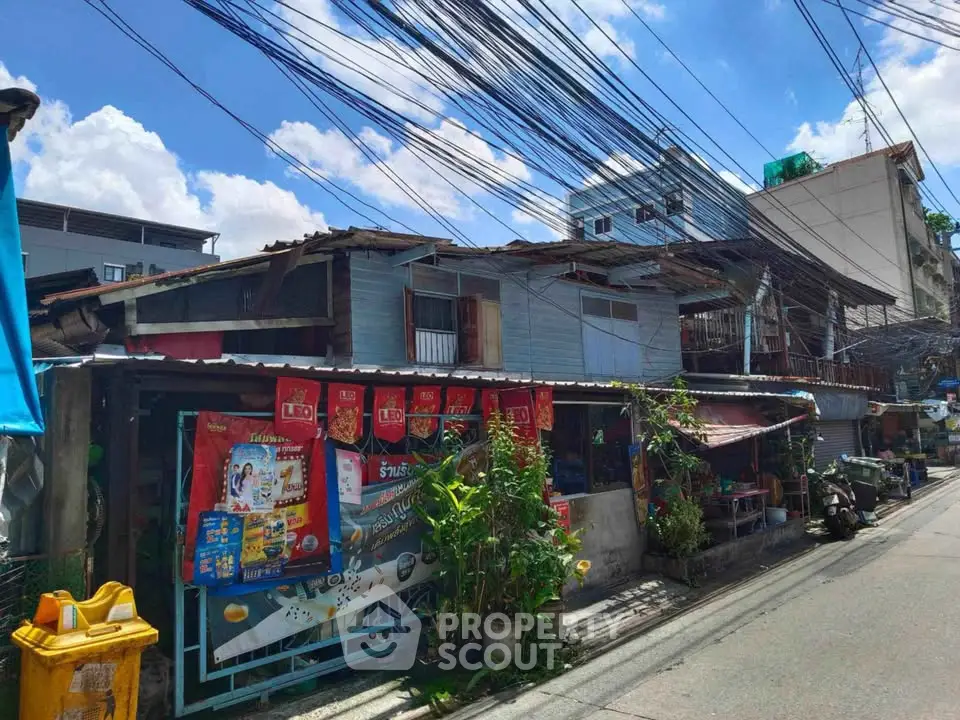 Charming urban street view with rustic buildings and vibrant banners under a clear blue sky.