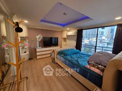 Spacious bedroom with city view, modern decor, and ample natural light