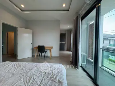 Spacious bedroom with balcony access and modern decor in a luxury apartment.