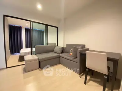 Modern living room with cozy gray sofa and dining area in open layout apartment