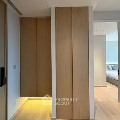 Modern interior with sleek wooden panels and cozy bedroom view, showcasing minimalist design.