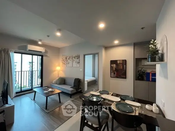 Modern open-plan living room with dining area and balcony access