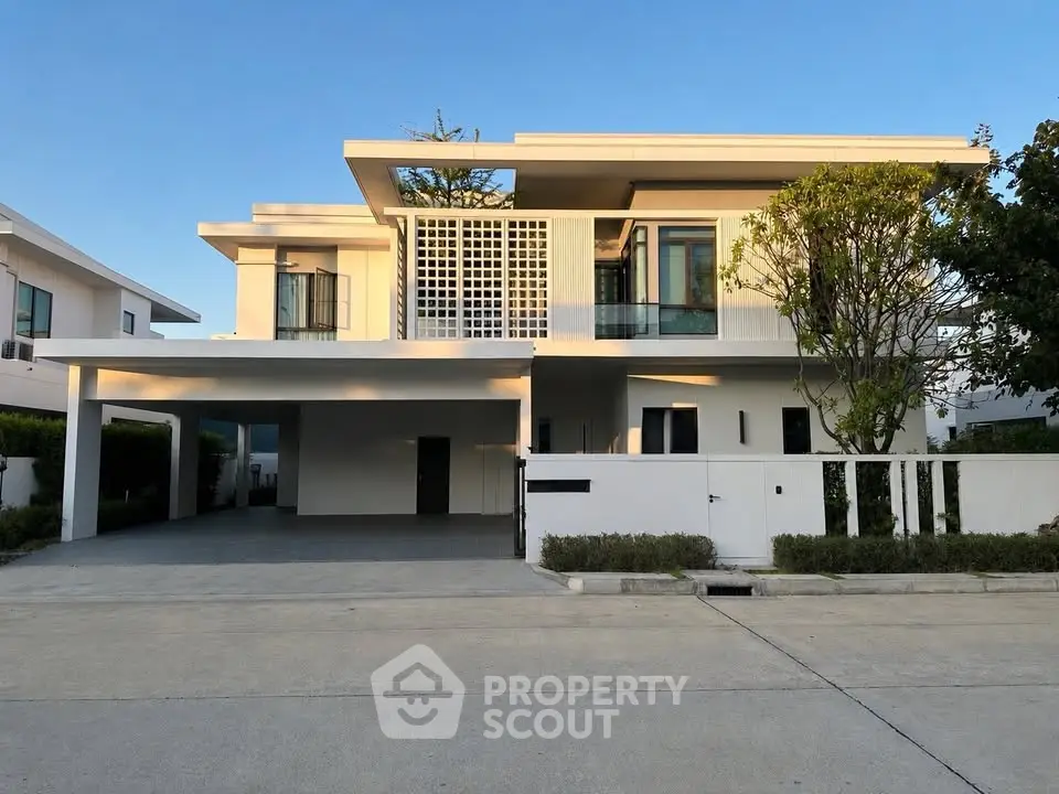 Modern two-story house with sleek design and spacious driveway in a serene neighborhood.