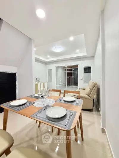 Modern dining area with elegant table setting and cozy living space, perfect for entertaining guests.