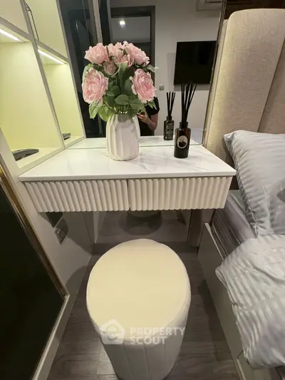Elegant bedroom vanity with floral decor and plush stool