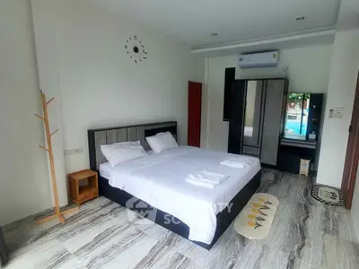 Spacious bedroom with modern decor and pool view