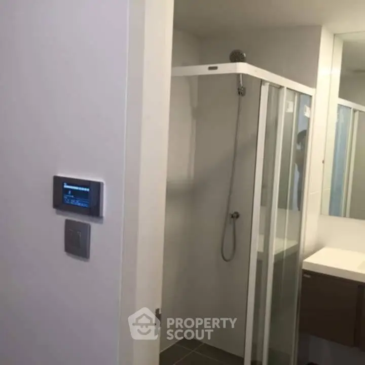 Modern bathroom with glass shower enclosure and sleek vanity unit.