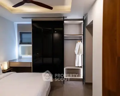 Modern bedroom with sleek black wardrobe and cozy lighting