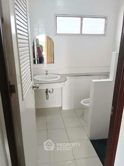 Compact bathroom with modern sink and small window