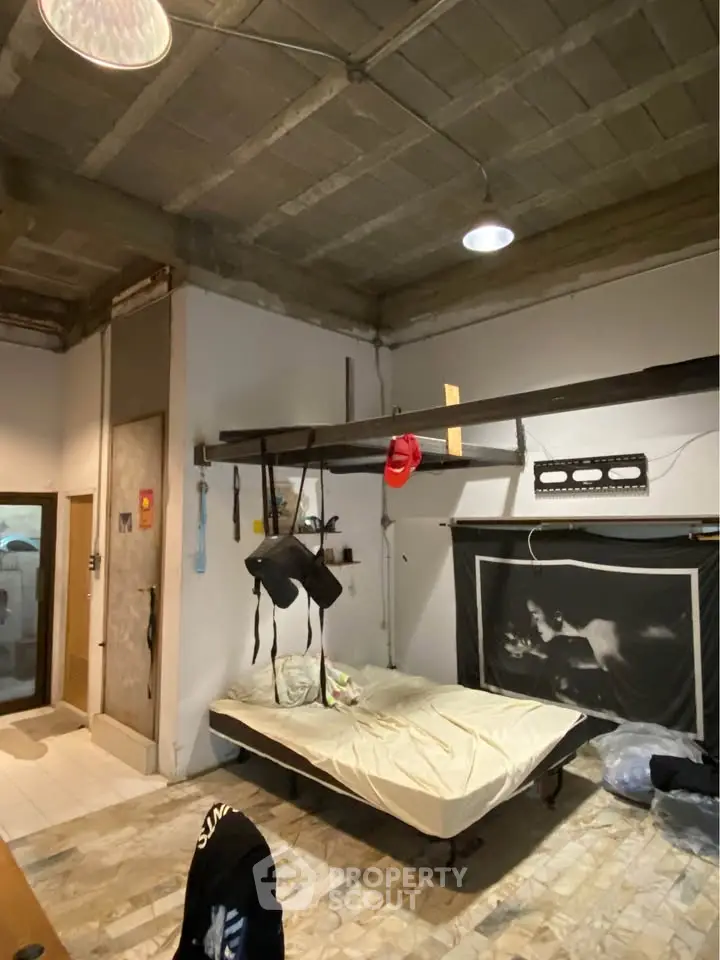 Industrial-style bedroom with exposed ceiling and unique decor elements.