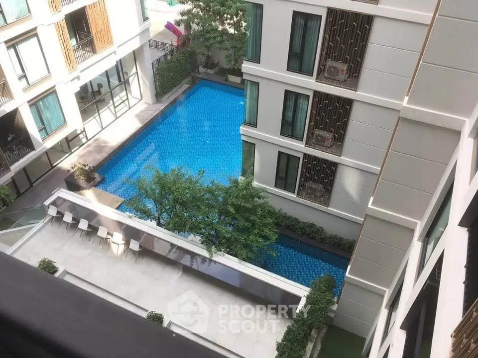 Luxurious apartment complex with stunning pool view and modern architecture.