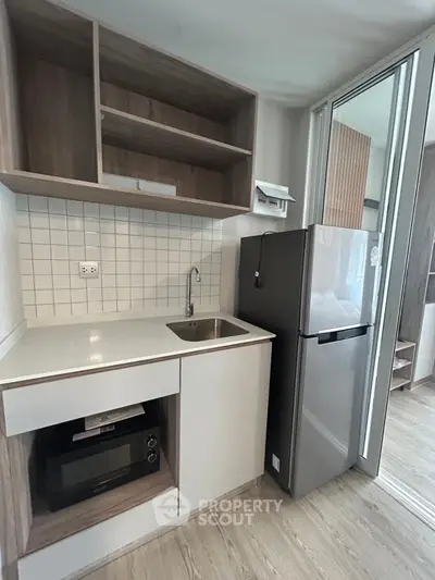 Modern compact kitchen with sleek appliances and stylish cabinetry