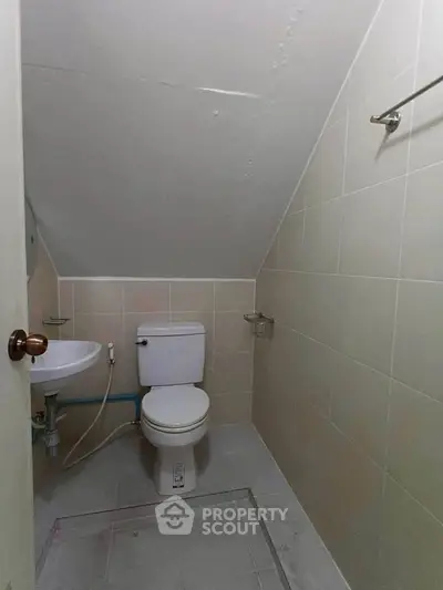 Compact bathroom with sloped ceiling and minimalist design