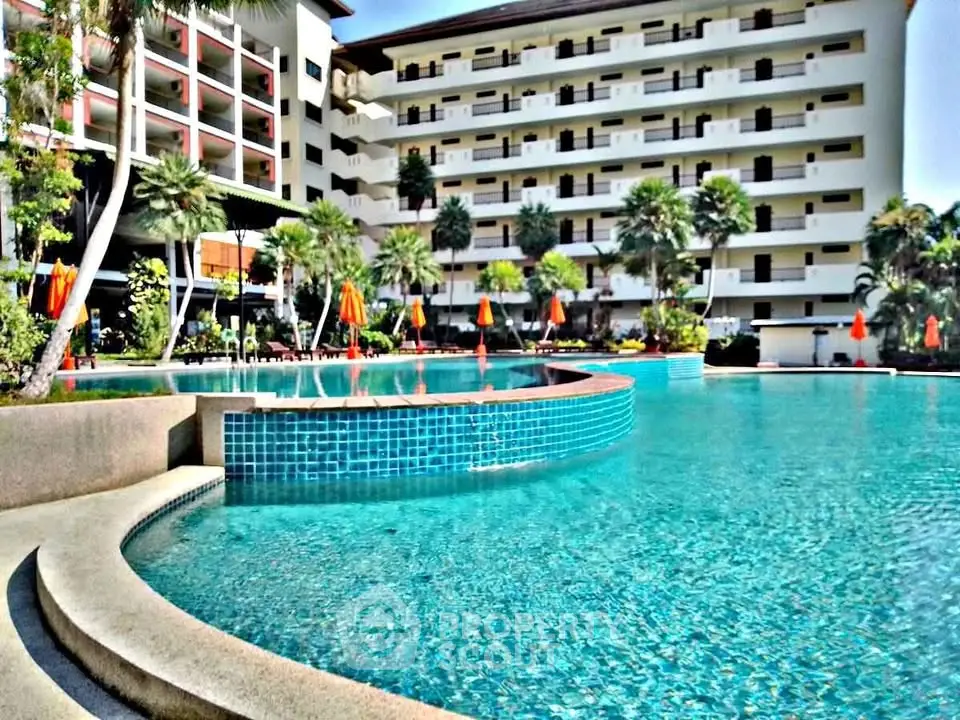 Luxurious hotel with stunning pool and palm trees, perfect for a tropical getaway.