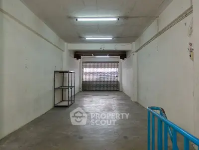 Spacious storage unit with metal shelving and secure roller door