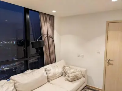 Cozy living room with city view, modern sofa, and elegant lighting.