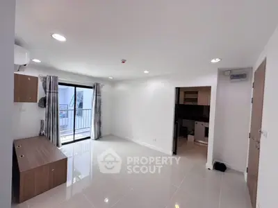 Spacious modern living room with balcony access and sleek tile flooring