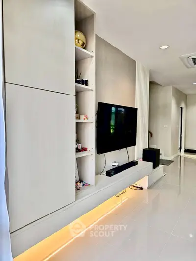 Modern living room with sleek built-in storage and wall-mounted TV