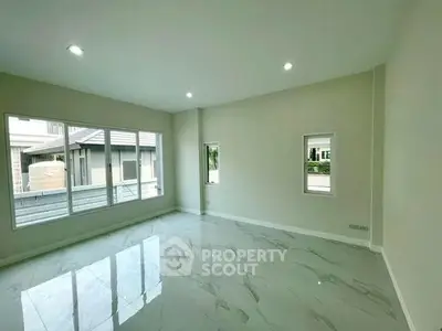 Spacious modern living room with large windows and glossy tile flooring