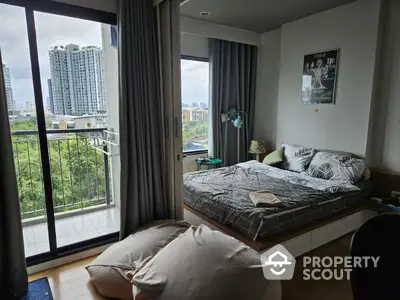 Modern bedroom with balcony and city view in high-rise apartment