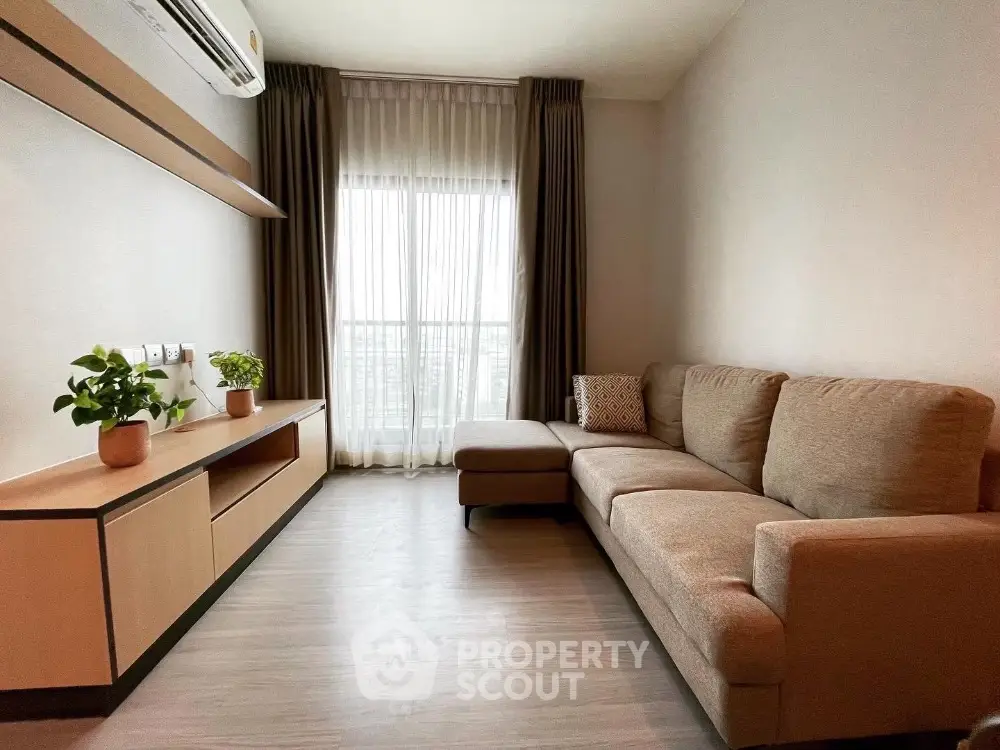 Modern living room with cozy sofa and large window offering natural light