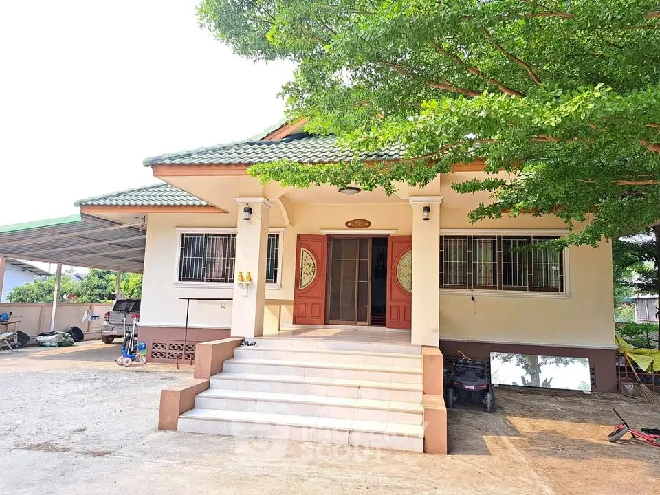 Charming single-story house with spacious front yard and lush greenery.