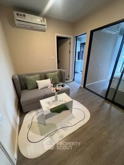 Cozy living room with modern decor and air conditioning, featuring a stylish sofa and coffee table.