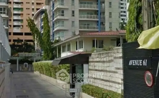 Modern residential building with lush greenery and secure entrance on Avenue 61.