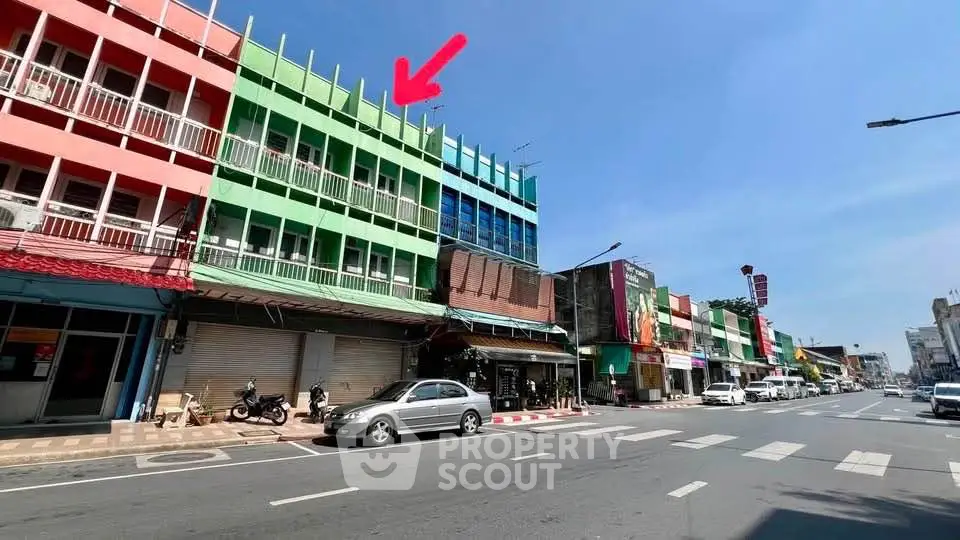 Vibrant commercial building exterior with colorful facade on a sunny street, ideal for business opportunities.