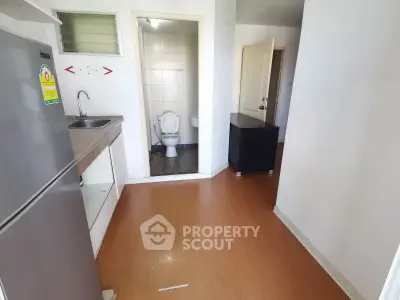 Compact apartment interior with kitchen and bathroom view, featuring modern appliances and minimalist design.