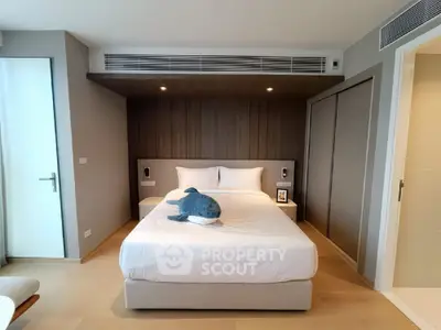 Modern bedroom with stylish decor and plush bedding in a contemporary apartment.