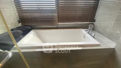 Luxurious bathroom with a modern bathtub and elegant blinds, perfect for relaxation.