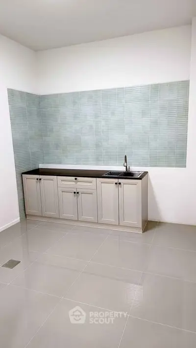 Modern minimalist kitchen with sleek cabinetry and tiled backsplash