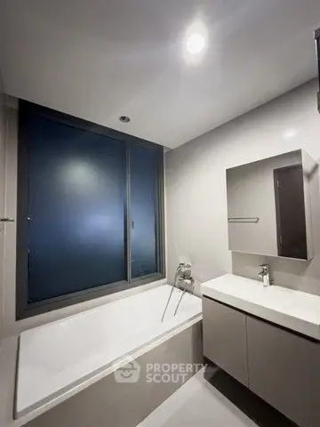 Modern bathroom with sleek design and large window for natural light.