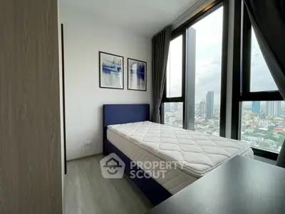 Modern bedroom with large windows offering stunning city views
