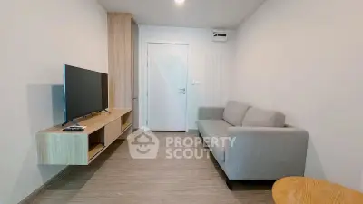 Modern living room with sleek furniture and mounted TV in a cozy apartment.