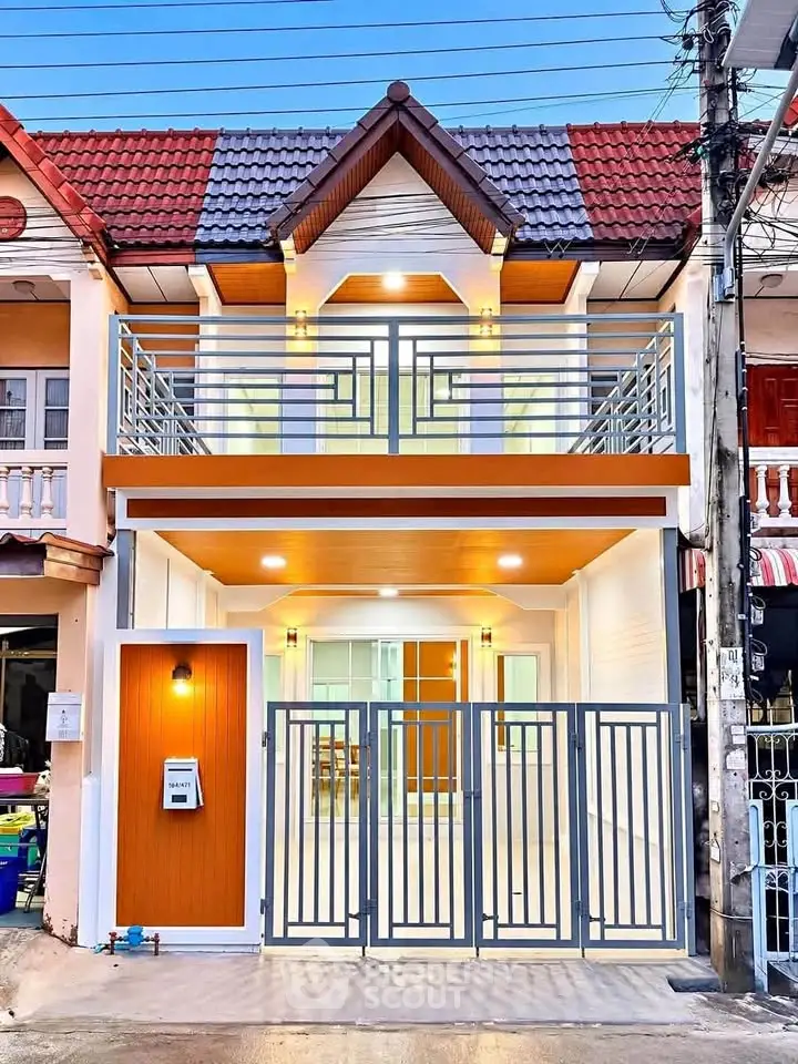 Charming two-story townhouse with modern facade and gated entrance, perfect for urban living.