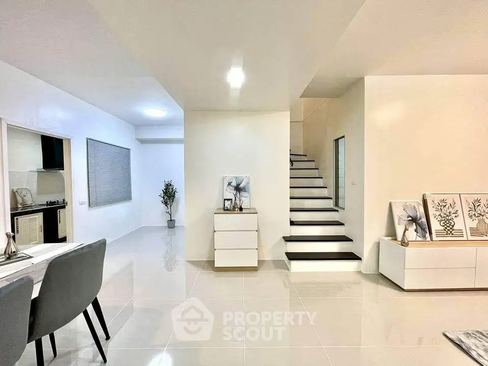 Modern open-plan living area with sleek staircase and stylish decor